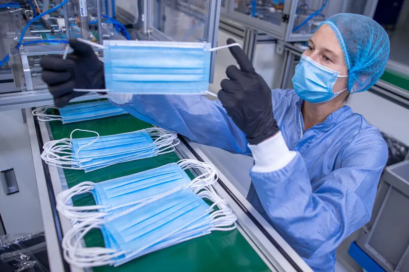 17 September 2020, Mecklenburg-Western Pomerania, Laage: An employee checks the production of protective masks at the medical technology company BM Bioscience Technology. Photo: Jens Büttner/dpa.