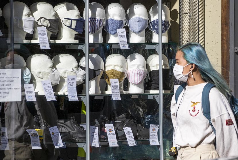 22 September 2020, Scotland, Edinburgh: A woman wearing a protective face mask walks past a shop selling masks in Edinburgh city centre, after First Minister Nicola Sturgeon announced a range of new measures to combat the rise in coronavirus cases in Scotland. Photo: Jane Barlow/dpa.