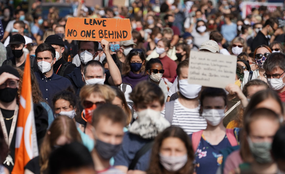 20 September 2020, Berlin: People march with placards during a demonstration held in favour of relocating asylum seekers to Germany from shelters on the Greek islands. Photo: Jörg Carstensen/dpa.