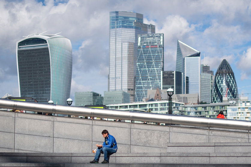 05 October 2020, England, London: A man sits and eats near the City Hall. According to official information, in Great Britain, more than half a million corona infections have already been detected. Photo: Dominic Lipinski/dpa.