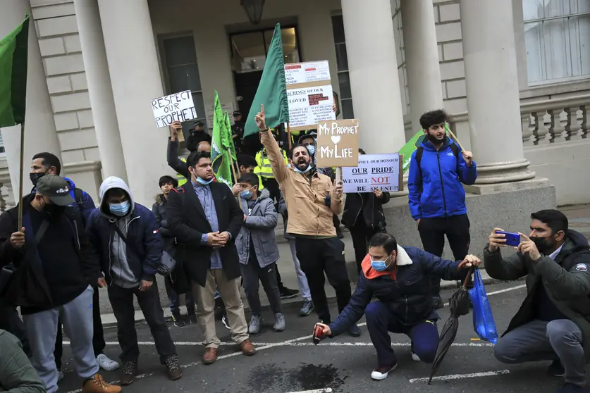 30 October 2020, England, London: Demonstrators hold banners and shout slogans in front of the French Embassy in London, during a protest against French President Emmanuel Macron&#39;s comments on Islam&#39;s prophet Muhammad cartoons. Photo: Aaron Chown/dpa.