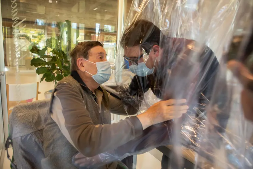 11 November 2020, Italy, Castelfranco Veneto: A resident (L) of the Domenico Sartor nursing home in Castelfranco Veneto embraces a visiting relative through a protective plastic sheet in a so-called &#34;Hug Room&#34; amid the new coronavirus pandemic. Photo: Filippo Ciappi/LaPresse via ZUMA Press/dpa