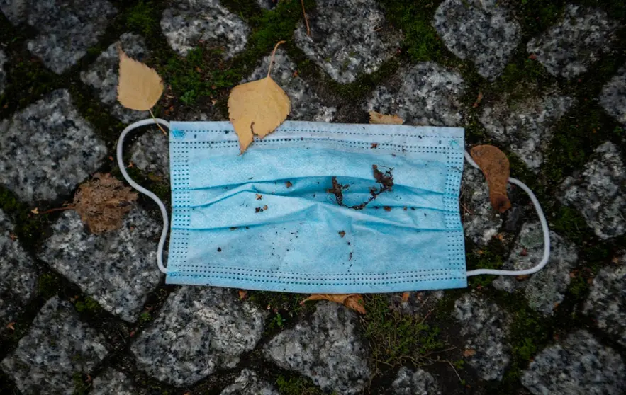 19 November 2020, Berlin: A face mask covered with some autumn leaves lies on the sidewalk. Public life in Germany has been brought to a near-standstill as part of a four-week shutdown in Europe's largest economy in a bid to stem a surge in coronavirus infections. Photo: Kira Hofmann/dpa-Zentralbild/dpa