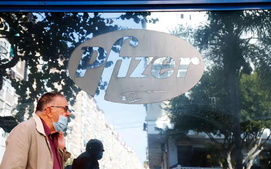 19 November 2020, Spain, Malaga: A man walks past the Pfizer pharmaceutical company headquarters in Malaga. Photo: Álex Zea/EUROPA PRESS/dpa