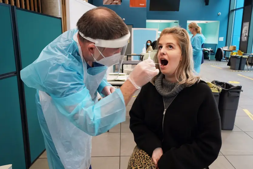 30 November 2020, England, Newcastle: Student Amy Hariot Ingle (R), 22, from Newcastle University, is being shown how to administer a Covid-19 test so she can self-test, by David Black an occupational heath specialist, as part of a coronavirus mass testing across the UK, which starts Tuesday. Photo: Owen Humphreys/PA Wire/dpa