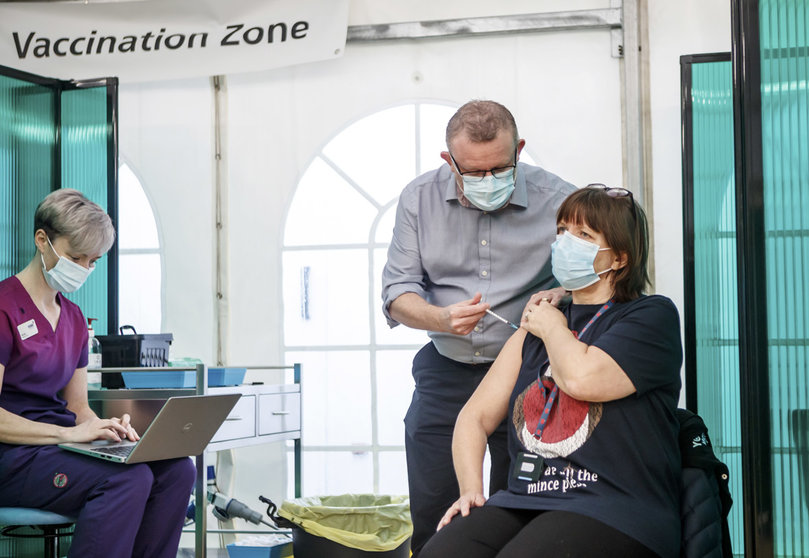 21 December 2020, England, York: Nurse practitioner York Medical Group Chris Pflueger (R) receives the Pfizer-BioNTech vaccine at a vaccination centre in York. Photo: Danny Lawson/PA Wire/dpa
