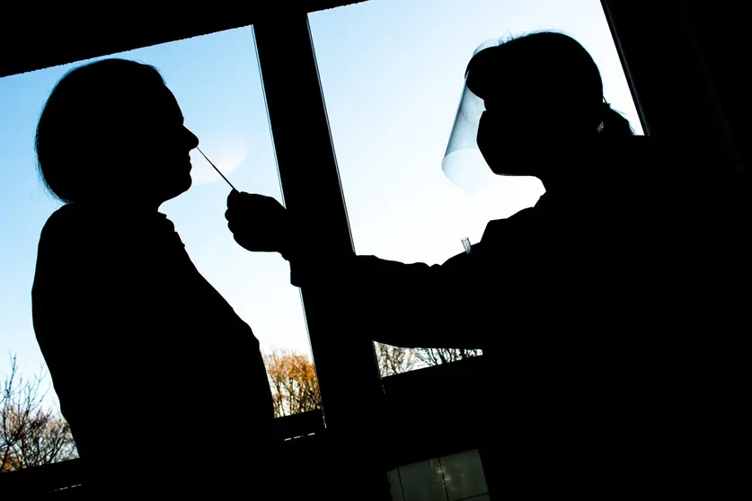 21 December 2020, Lower Saxony, Oldenburg: A nurse takes a swab for a rapid test to detect coronavirus at a senior living centre. Rapid tests are designed to allow visits from relatives over the Christmas holidays and prevent outbreaks in care homes. Photo: Hauke-Christian Dittrich/dpa