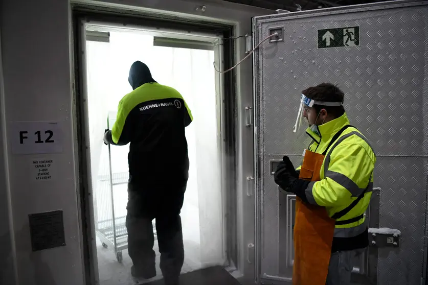 HANDOUT - 26 December 2020, North Rhine-Westphalia, ---: Employees of logistics companies work on the first shipment of the Pfizer-BioNTech coronavirus vaccine which arrived at the central warehouse of North Rhine-Westphalia. The vaccine, which is filled into small vials, must be stored at minus 70 degrees. Photo: Mark Hermenau/Staatskanzlei des Landes Nordrhein-Westfalen/dpa - ATTENTION: editorial use only and only if the credit mentioned above is referenced in full