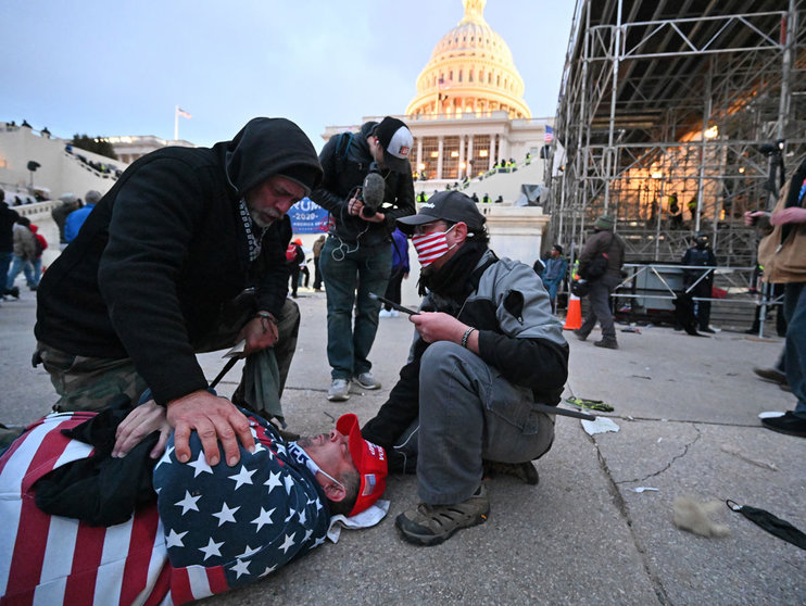 06 January 2021, US, Washington: A man lies on the ground after having been hit with a rubber bullet allegedly fired by the US Capitol Police as supporters of US President Donald Trump storm the US Capitol building where lawmakers were due to certify president-elect Joe Biden's win in the November election. Photo: Essdras M. Suarez/ZUMA Wire/dpa