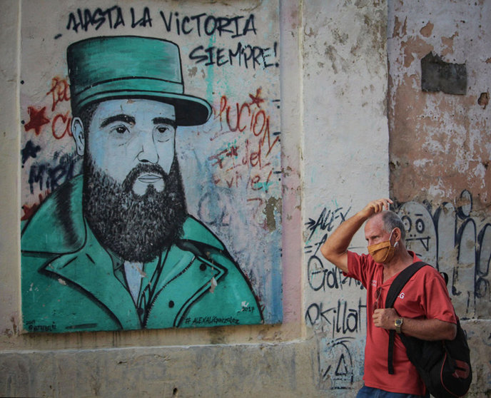 FILED - A man with a mouth-and-nose guard walks in front of a mural of former Cuban President Fidel Castro. In Cuba, 5310 people have contracted Covid-19. Photo: Guillermo Nova/dpa