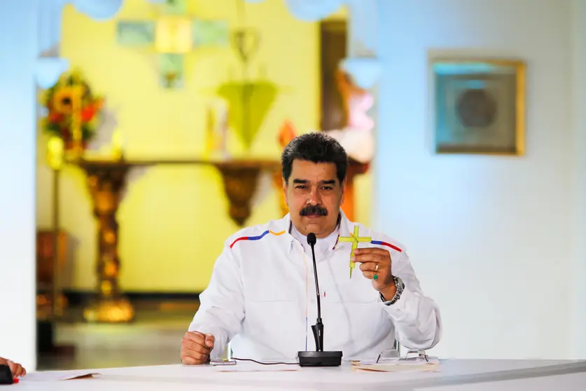 HANDOUT - 28 March 2021, Venezuela, Caracas: Nicolas Maduro, president of Venezuela, holds a cross during a press conference. Maduro has offered to swap oil for COVID-19 vaccines in view of rapidly rising coronavirus numbers as well as US sanctions against the crisis-torn South American state. Photo: Jhonn Zerpa/Prensa Miraflores/dpa - ATTENTION: editorial use only and only if the credit mentioned above is referenced in full