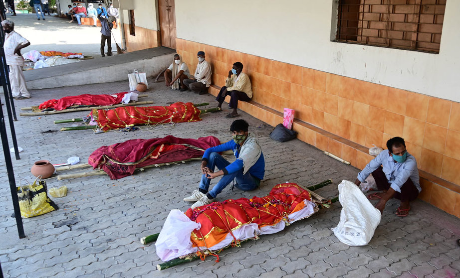 27 April 2021, India, Prayagraj: Family members wait with bodies of their relatives who died of Covid-19 to be cremated at an electric crematorium in Prayagraj. India hit record numbers of Covid-19 infections worldwide for the sixth day running on Tuesday, as health systems buckled under the pressure, and shortages of medical oxygen and hospital beds led to more deaths. Photo: Prabhat Kumar Verma/ZUMA Wire/dpa