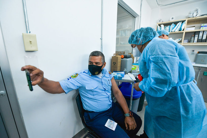 05 May 2021, El Salvador, San Salvador: A firefighter takes a selfie while a health worker administers him the second dose of the Chinese Corona vaccine Coronavac. Photo: Camilo Freedman/SOPA Images via ZUMA Wire/dpa