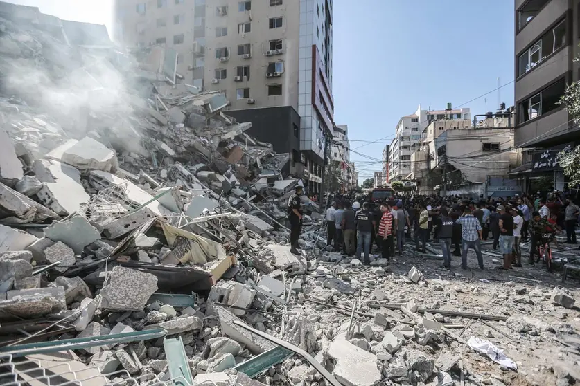 14 May 2021, Palestinian Territories, Gaza City: Palestinians inspect the remains of Al-Jalaa tower, which housed several media outlets including The Associated Press and Al Jazeera, after it was hit by an Israeli airstrike amid the escalating flare-up of Israeli-Palestinian violence. Photo: Mohammed Talatene/dpa