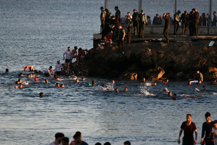 17 May 2021, Spain, Ceuta: Spanish civil guard officers try to stop people from Morocco from entering the Spanish enclave of Ceuta. Photo: Antonio Sempere/EUROPA PRESS/dpa