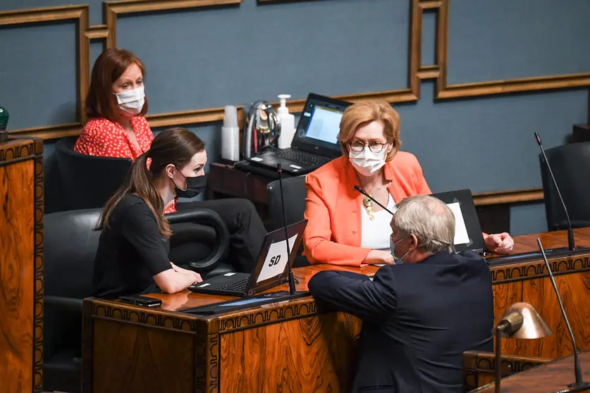 Minister of Employment Tuula Haatainen (R), with Prime Minister Sanna Marin (L) talking with the former Prime Minister Antti Rinne in Parliament. Photo: Kimmo Brandt/Eduskunta.