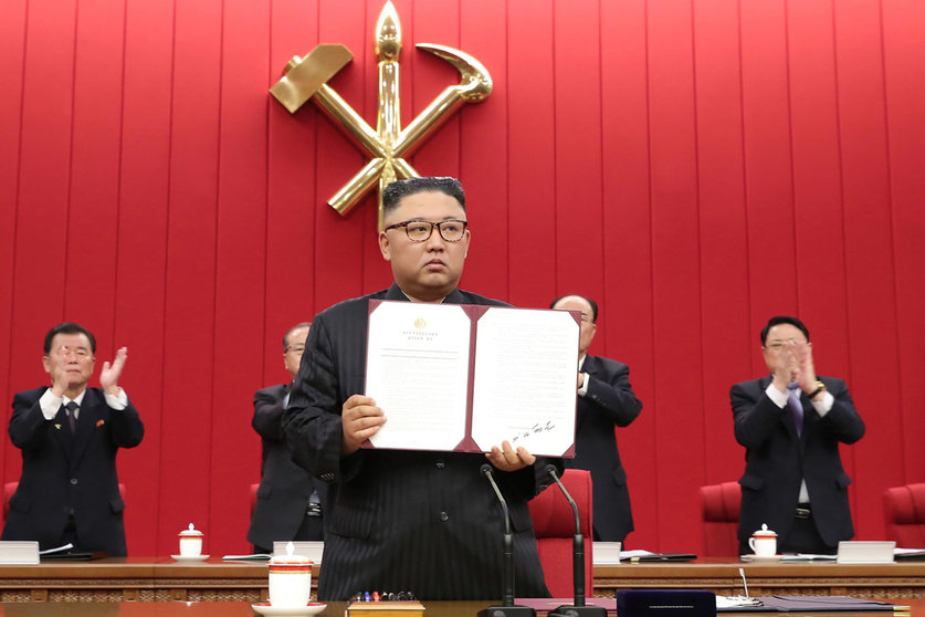 HANDOUT - 17 June 2021, North Korea, Pyongyang: A picture provided by the North Korean state news agency (KCNA) on 18 June 2021, shows North Korean leader Kim Jong-un holding up a document carrying his signature at the third plenary meeting of the eighth Central Committee of North Korea's Workers' Party on its third-day to discuss international affairs, including the Biden administration's North Korea policy. Photo: -/KCNA/dpa - ATTENTION: editorial use only and only if the credit mentioned above is referenced in full
