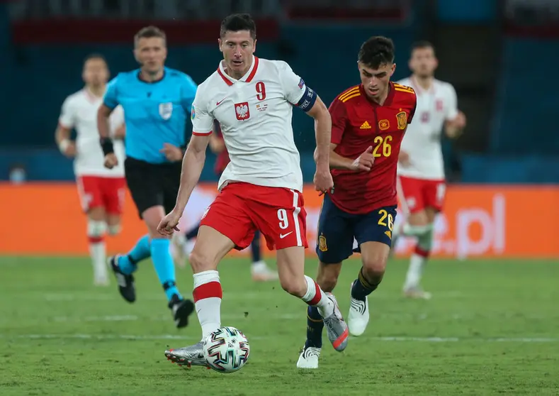 19 June 2021, Spain, Seville: Poland's Robert Lewandowski (L) and Spain's Pedri battle for the ball during the UEFA EURO 2020 Group E soccer match between Spain and Poland at La Cartuja Stadium. Photo: Cezaro De Luca/dpa