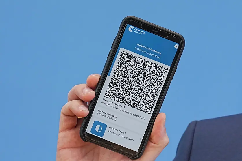10 June 2021, England, Berlin: German Minister of Health Jens Spahn shows the app for the digital vaccination certificate during a press conference on the coronavirus situation. Photo: Michael Kappeler/dpa