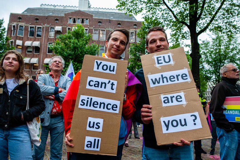21 June 2021, Netherlands, Amsterdam: Two men hold placards asking for help to the Europe Union during a demonstration against this legislation by Hungary's parliament bans the dissemination of content in schools deemed to ˜promote homosexuality and gender change. Photo: Ana Fernandez/SOPA Images via ZUMA Wire/dpa.