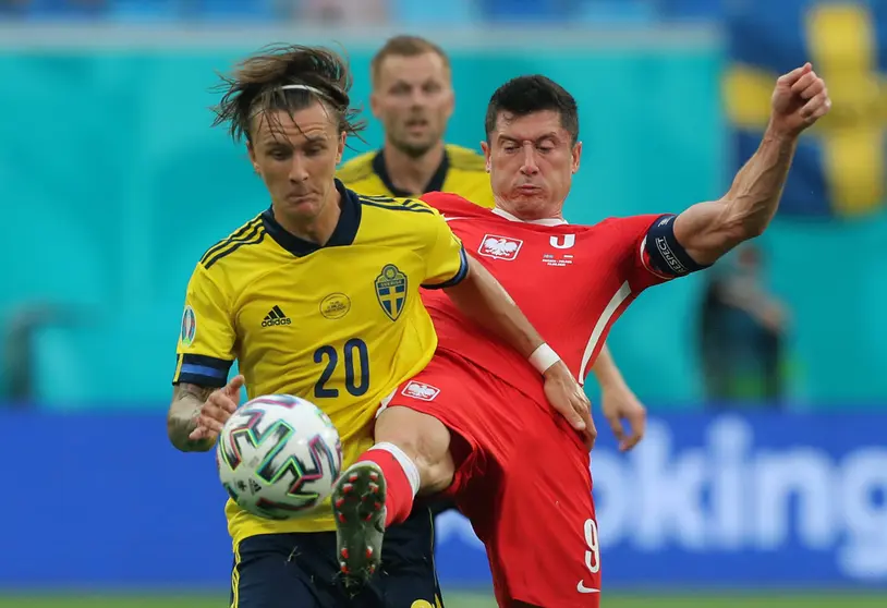 23 June 2021, Russia, St. Petersburg: Sweden's Kristoffer Olsson (L) and Poland's Robert Lewandowski battle for the ball during the UEFA EURO 2020 Group E soccer match between Sweden and Poland at St. Petersburg Stadium. Photo: Igor Russak/dpa.