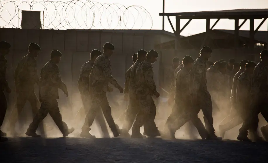 FILED - 03 October 2013, Afghanistan, Kunduz: Bundeswehr soldiers walk across the dusty deployment site after a roll call. Germany has withdrawn the last Bundeswehr soldiers from Afghanistan, ending its mission in the country, sources told DPA on Tuesday evening. Photo: Michael Kappeler/dpa