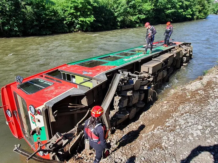 HANDOUT - 09 July 2021, Austria, Ramingstein: A carriage of a regional train lies in the Mur River after a train with dozens of children and teenagers on board derailed in Austria and plunged into a river. According to the rescue commander Anton Schilcher, 17 people were slightly injured in the accident in the province of Salzburg on Friday. Photo: Wasserrettung Lv Salzburg/WASSERRETTUNG LV SALZBURG/dpa - ATTENTION: editorial use only in connection with the latest coverage and only if the credit mentioned above is referenced in full