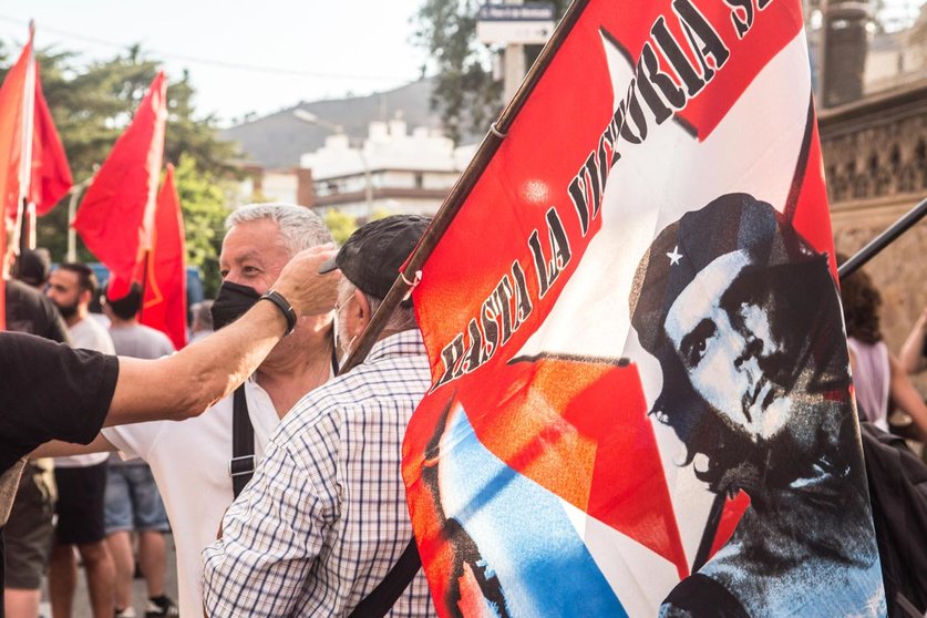 15 July 2021, Spain, Barcelona: A protester holds a flag with the face of Ernesto Che Guevara that says, until victory during a demonstration in front of the US Consulate in Barcelona against the United States blockade of Cuba and in solidarity with the Cuban peopl. Photo: Thiago Prudencio/SOPA Images via ZUMA Wire/dpa.