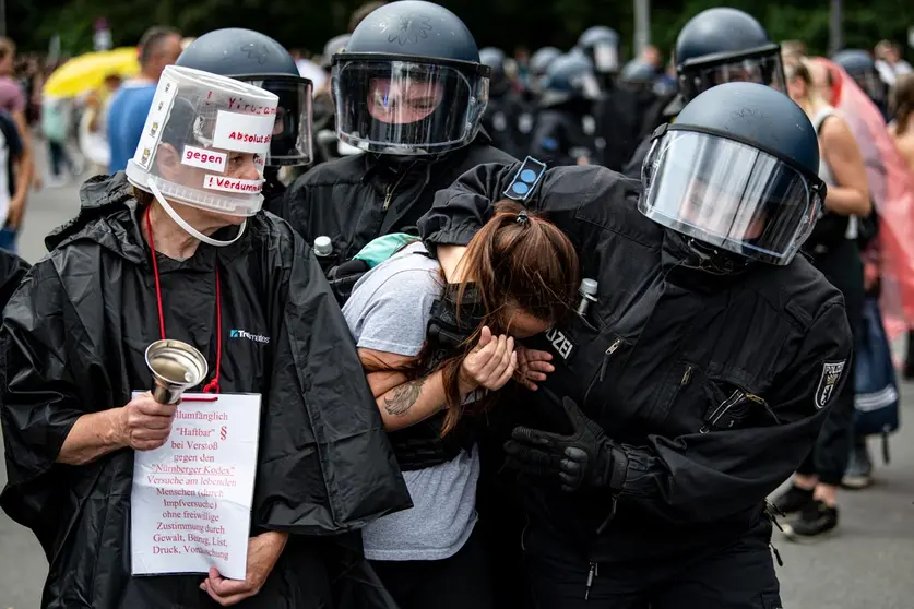 01 August 2021, Berlin: Policemen detain a woman taking part in an unannounced demonstration against the Coronavirus measures despite a ban on protests. Photo: Fabian Sommer/dpa