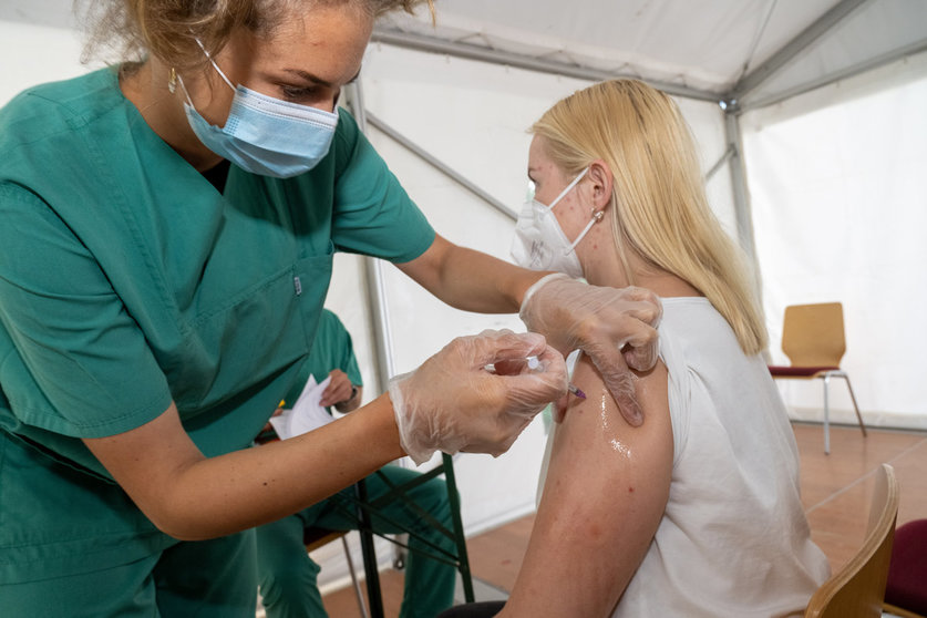 02 August 2021, Mecklenburg-West Pomerania, Lubmin: Anastasia Grawe gets vaccinated against the coronavirus by a medical employee in a tent of the municipality on the beach in the district of Vorpommern-Greifswald. Photo: Stefan Sauer/dpa