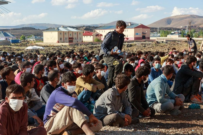 03 August 2021, Turkey, Caldiran: About 400 refugees from Afghanistan, Pakistan and Iran, picked up by Turkish police, wait at a checkpoint near the city of Caldiran, close to Turkey's border with Iran. About 300 of them were found crammed into a truck. Photo: Bradley Secker/dpa
