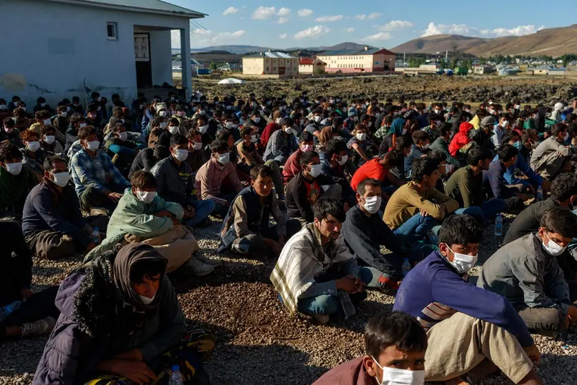 03 August 2021, Turkey, Caldiran: About 400 refugees from Afghanistan, Pakistan and Iran, picked up by Turkish police, wait at a checkpoint near the city of Caldiran, close to Turkey's border with Iran. About 300 of them were found crammed into a truck. Photo: Bradley Secker/dpa