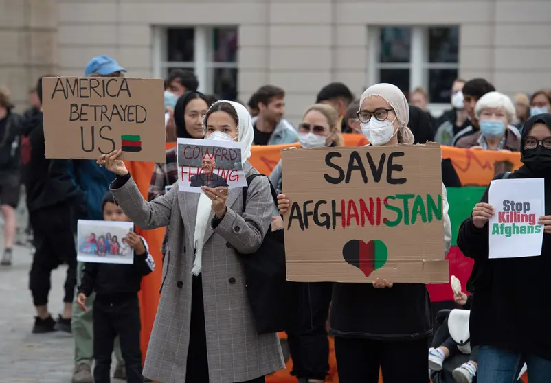 17 August 2021, Brandenburg, Potsdam: People stand with placards on the Old Market Square during the rally "Humanitarian Airlift Now - Don't Abandon Afghanistan's People". Photo: Paul Zinken/dpa