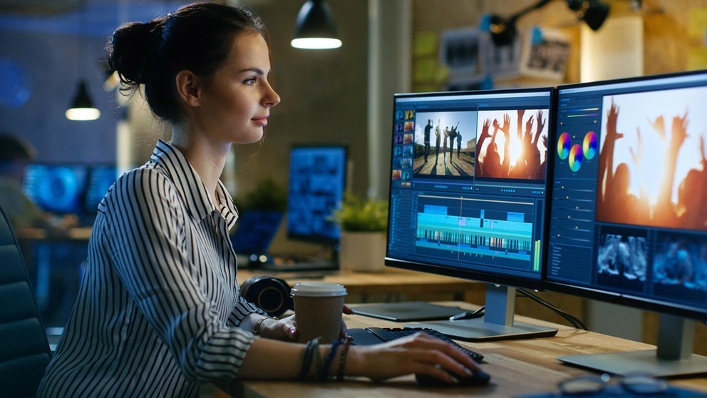 A worker doing video editing tasks with a computer in her office. Photo: Pixabay.