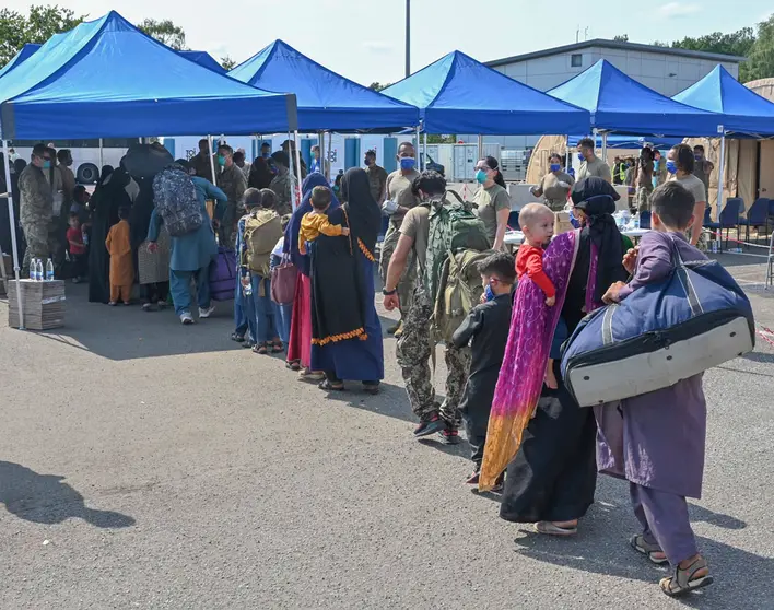 21 August 2021, Rhineland-Palatinate, Ramstein-Miesenbach: Afghan refugees evacuated from Kabul line up for processing after arrival from Kabul at Ramstein Air Base. Ramstein Air Base provides temporary housing for evacuees from Afghanistan as part of Operation Allies Refuge. Photo: Ssgt. Emma James/Planet Pix via ZUMA Press Wire/dpa