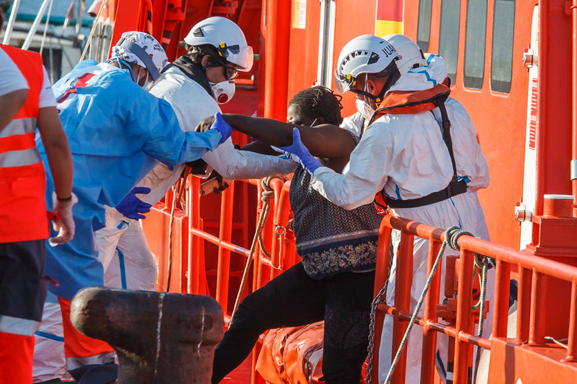 25 August 2021, Spain, Arguineguin: Employees of the sea rescue service help a migrant to disembark the vessel Guardamar Talia. The Coast Guard spotted 46 sub-Saharan migrants south of Arguineguin. Among the occupants of the boat were 30 men, 14 women and two minors. Photo: Europa Press/EUROPA PRESS/dpa