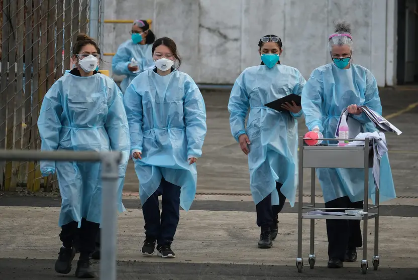 23 August 2021, Australia, Melbourne: Health workers arrive at a drive-through COVID-19 Vaccination Centre in the suburb of Campbellfield. Victoria has recorded 71 new locally-acquired coronavirus cases, of which 49 are linked to known outbreaks. Photo: Luis Ascui/AAP/dpa