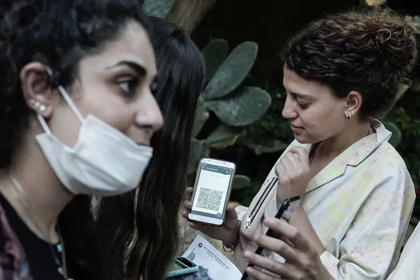 18 August 2021, Israel, Abu Gosh: Wedding guests present a green passport from the Health Ministry based on a smartphone app before entering. The government has imposed new restrictions as Israel battles the fourth wave of coronavirus, which is predominantly of the delta variety. The green passport will only be issued to people who are fully vaccinated or have recovered from a corona infection. Photo: Nir Alon/ZUMA Press Wire/dpa