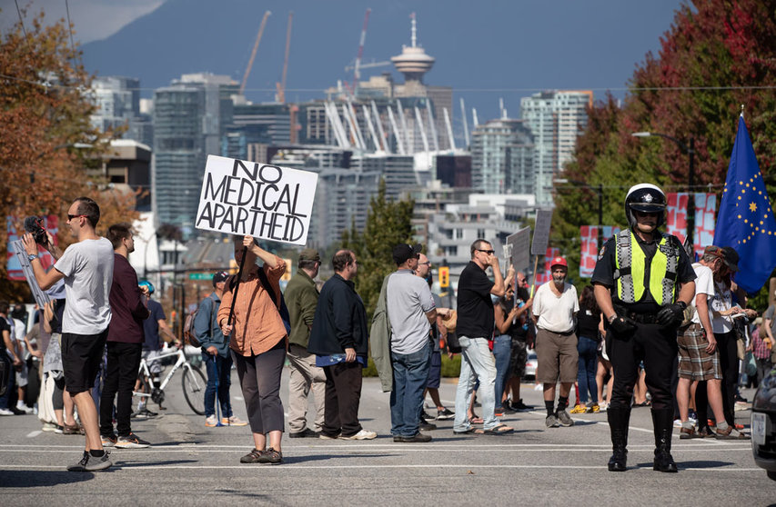 08 September 2021, Canada, Vancouver: A police officer directing traffic around the road closure stands by as people attend a rally organized by those opposed to COVID-19 vaccination passports and public health measures. Photo: Darryl Dyck/The Canadian Press via ZUMA/dpa
