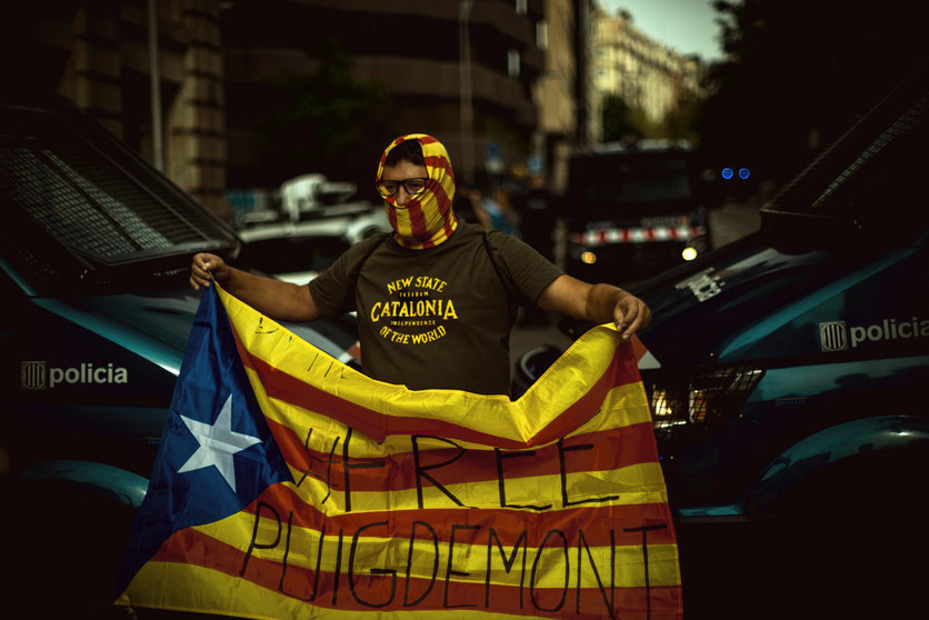 24 September 2021, Spain, Barcelona: A protester holds a Catalan pro-independence flag during a protest near the Italian Consulate General in Barcelona against the arrest of Catalan ex-government leader Carles Puigdemont. The former Catalan head of government Puigdemont has been arrested on the Italian Mediterranean island of Sardinia. Photo: Matthias Oesterle/ZUMA Press Wire/dpa