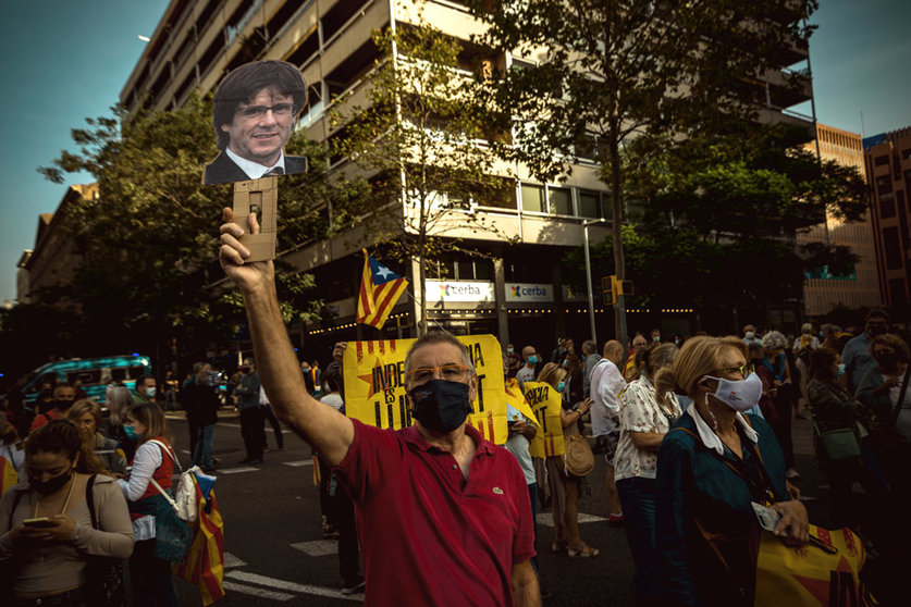 24 September 2021, Spain, Barcelona: A protester holds a picture of Carles Puigdemont during a protest near the Italian Consulate General in Barcelona against the arrest of Catalan ex-government leader. The former Catalan head of government Puigdemont has been arrested on the Italian Mediterranean island of Sardinia. Photo: Matthias Oesterle/ZUMA Press Wire/dpa