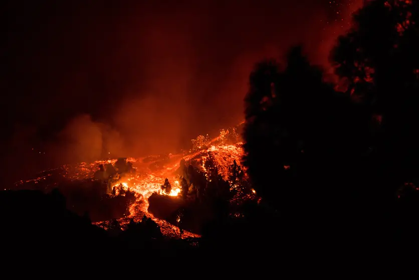 19 September 2021, Spain, La Palma: Lava and smoke comes out of the volcano Cumbre Vieja on the Canary island of La Palma. A volcano erupted on the Spanish island of La Palma on Sunday, with several explosions in the El Paso municipality in the south of the island forcing at least 2000 people to flee the area, according to local media. Photo: Arturo Jimenez/dpa