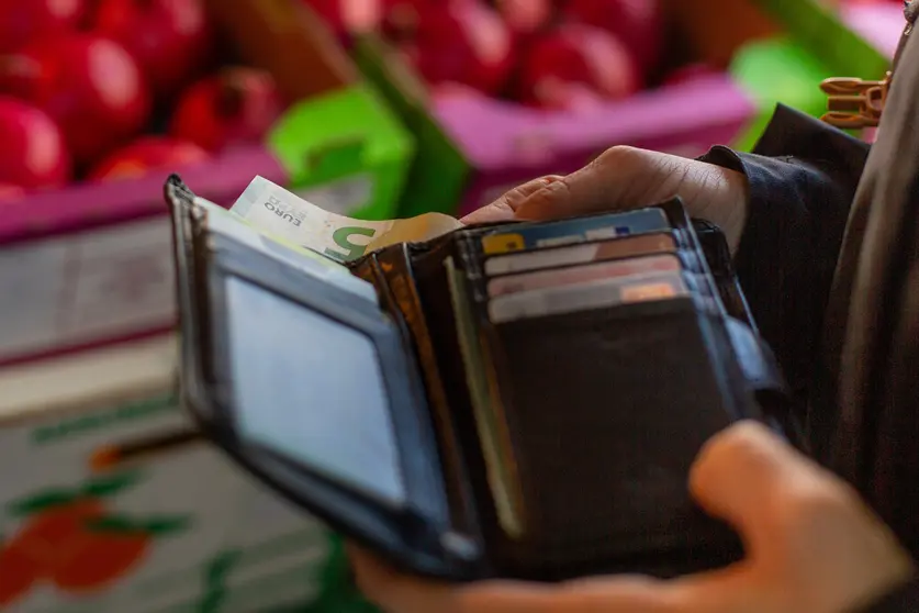 FILED - A woman takes a 5-euro note out of her purse in this illustrative shot from April 29, 2021. Photo: Fernando Gutierrez-Juarez/dpa-Zentralbild/dpa.