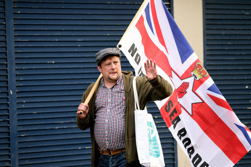 17 September 2021, United Kingdom, Belfast: An anti Northern Ireland Protocol protester holds a flag during a rally against the post-Brexit arrangements in Newtownards Road. Photo: Peter Morrison/PA Wire/dpa