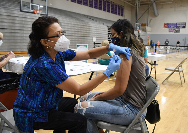 11 September 2021, US, Winter Springs: Nurse Susanna Bryan (L) administers a dose of the Pfizer COVID-19 vaccine to Joann Cortes at a vaccination clinic at Winter Springs High School. As of 10 September 2021, 54% of Florida's population has been fully vaccinated. Photo: Paul Hennessy/SOPA Images via ZUMA Press Wire/dpa