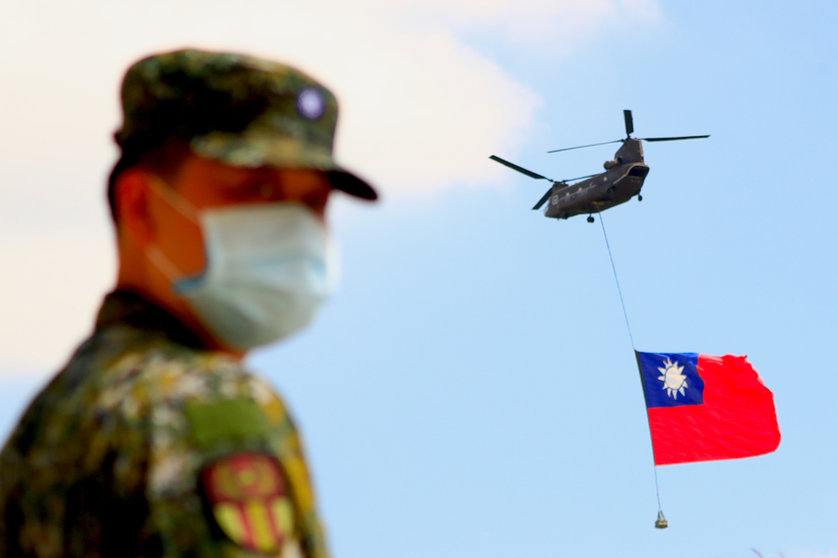 A soldier stands guard on Monday as a Chinook Helicopter carrying a tremendous Taiwan flag flies over a military camp, part of a rehearsal for the flyby performance for Taiwan's Double-Ten National Day Celebration. Taiwan condemned China on Saturday for sending 38 warplanes into its airspace the day before, the largest ever incursion reported. Photo: Daniel Ceng Shou-Yi/ZUMA Press Wire/dpa