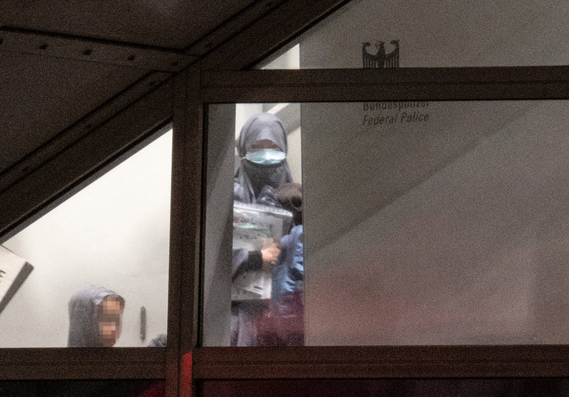 A veiled woman wearing a mask enters a screened-off area of the Federal Police at Frankfurt Airport from the gangway of a charter plane with two small children. In an action that was initially kept secret, the German government, in cooperation with the US Army, had taken a total of eight German female supporters of the terrorist militia "Islamic State" (IS) and their 23 children from a prison camp in Syria as part of a humanitarian operation. The women were brought to Germany via Kuwait on a charter plane, where almost all of them were immediately taken into custody. Photo: Boris Roessler/dpa