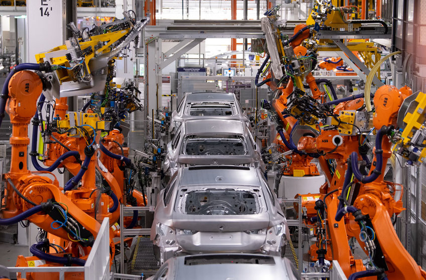 22 October 2021, Bavaria, Munich: Robot arms work on the bodywork of various BMW models at the main plant in Munich. Three months after starting the BMW iX electric SUV production, the German giant carmaker has now also started series production of the all-electric BMW i4. Photo: Sven Hoppe/dpa