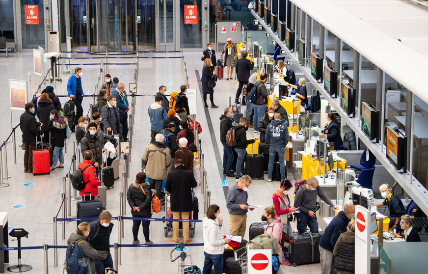 29 October 2021, Bavaria, Munich: Passengers stand at a check-in counter at Munich Airport. In Bavaria, the autumn holidays start on 29 October 2021. Photo: Sven Hoppe/dpa
