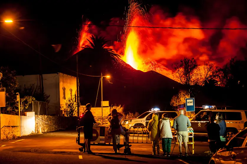 28 October 2021, Spain, La Palma: A group of people watch the lava flow and pyroclasts coming out of the Cumbre Vieja volcano in La Palma in the Canary Islands. The lava now covers a total of 911.6 hectares and has destroyed 2,183 buildings. Photo: -/EUROPA PRESS/dpa